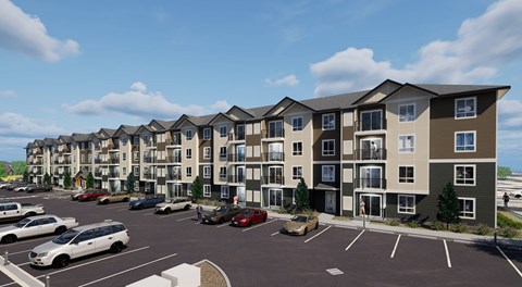 A row of modern apartment buildings with cars parked in the lot.
