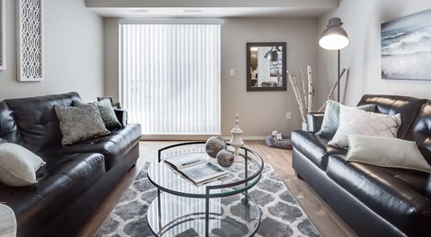 A living room with two couches and a glass coffee table.