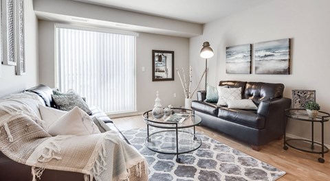 A living room with couches, coffee table and large glass sliding door