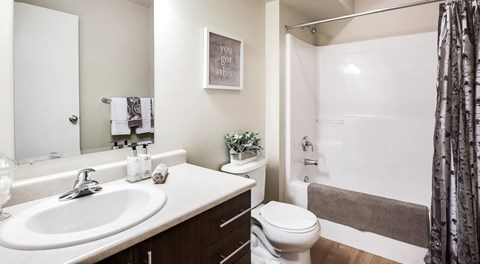 A bathroom with a white sink, toilet, and a bathtub