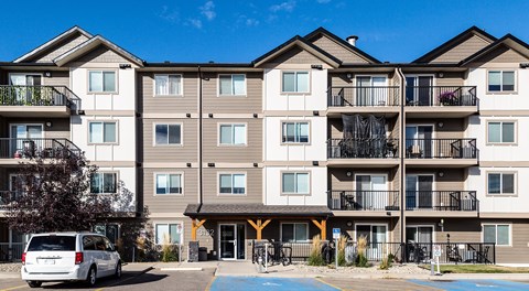 An apartment building with parking spaces in front