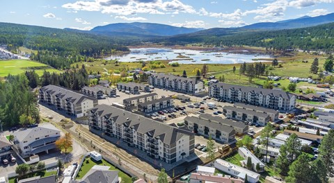 A large residential complex with both apartments and townhomes with parking located in between buildings