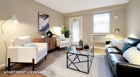 An Apartment living room with a couch, coffee table and chairs. A single patio door with windows, an AC unit sits below a standard sized window