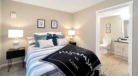 A bedroom with queen sized bed, night stands and an ensuite bathroom