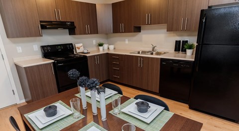 A kitchen with a black appliance and brown cabinets.