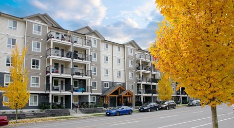A large apartment building with street parking out front