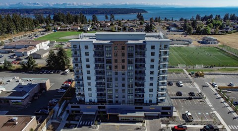 A large white building with a parking lot in front of it.