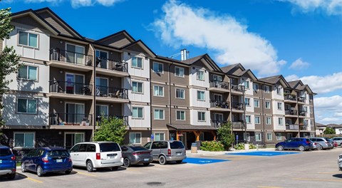 A large apartment complex with parking out front