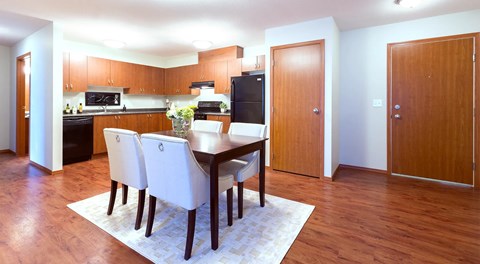 A kitchen with a dining table and chairs.