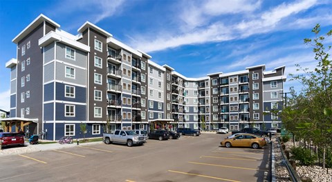A six storey apartment complex with a parking lot in front