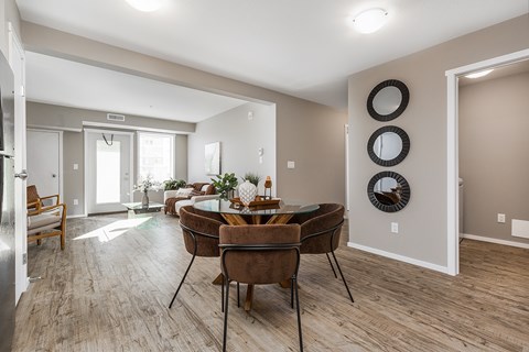 A modern dining room with a wooden table and chairs.