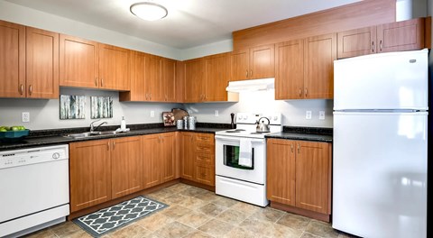 A kitchen with wooden cabinets and white appliances.