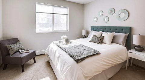 A bedroom with a large bed and a window.