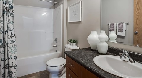 A bathroom with a toilet, sink, and shower.