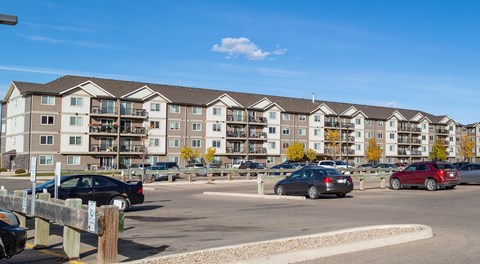 Large apartment building with large parking lot in front