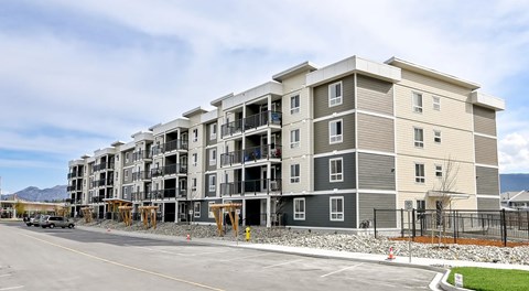 A four storey apartment building with parking in front