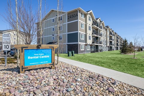 A rental centre sign is in front of apartment buildings.