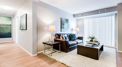 Apartment living room with couch, coffee table and end table. with large glass sliding door