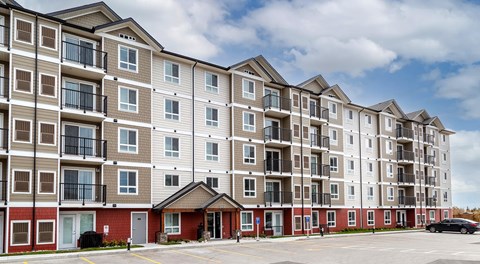 A five storey apartment building with parking in front