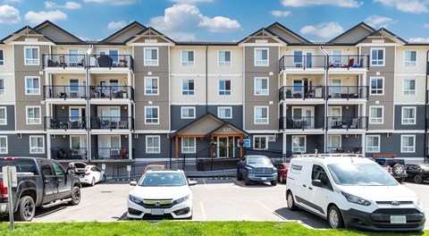 A four storey apartment building with parking in front