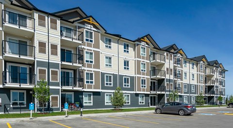 A large apartment building with parking in front