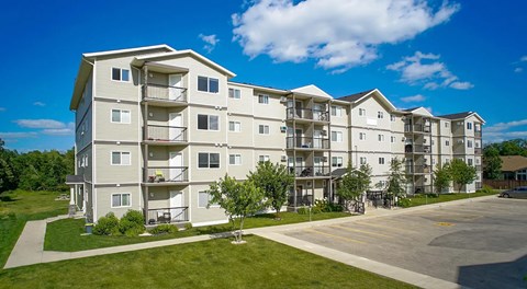 A large apartment building with parking in front