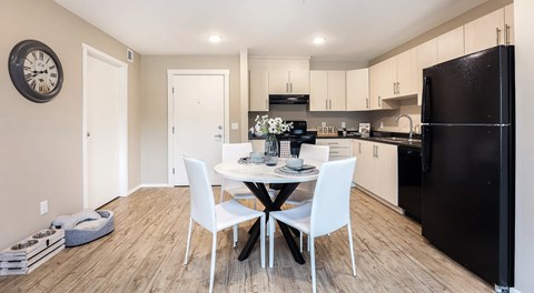 A apartment kitchen light cabinets and black appliances