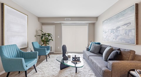 A living room with a grey couch, two chairs, and a coffee table.