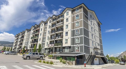 A six storey apartment building with parking in front