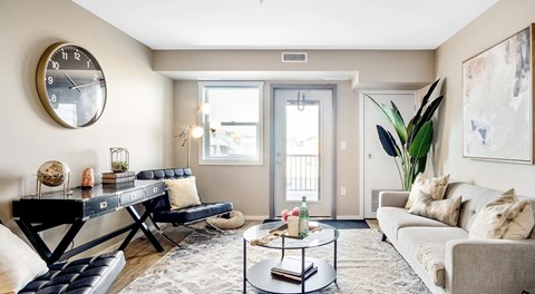A living room with couch, two chairs, coffee table and patio door