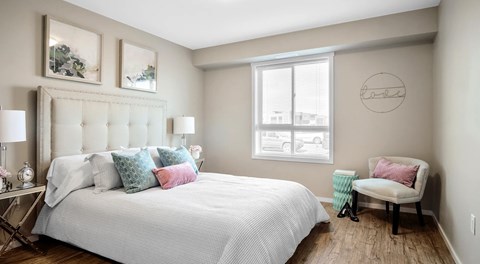A bedroom with a large bed and a chair.