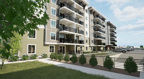 A modern apartment building with balconies and a parking lot in front.