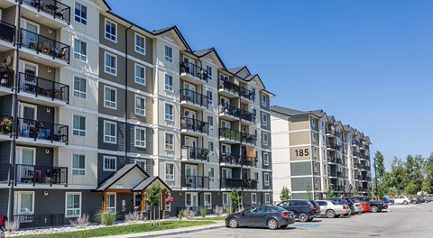 A large six storey apartment building with parking in front