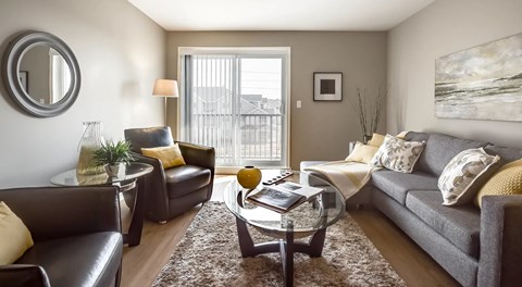 A living room with couch, coffee table and two arm chairs.