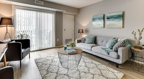 A living room with a couch, coffee table, a couple end tables and two arm chairs.