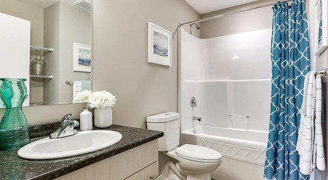 A bathroom with a white toilet, a sink, and a bathtub.