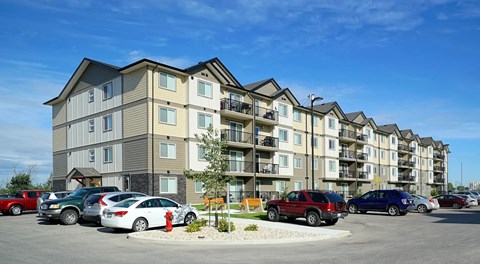 An apartment building with parking along the front and side