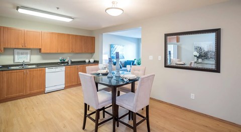 A kitchen with a dining table and chairs.