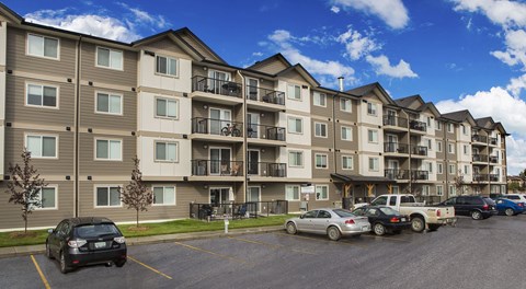 An apartment building with a large parking lot out front