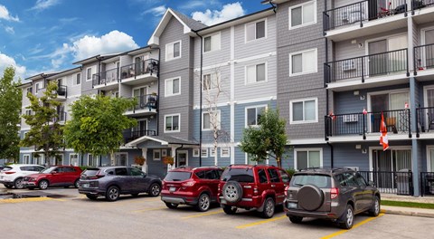 A large apartment building with parking in front