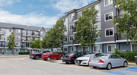 Two large apartment buildings with parking along both buildings