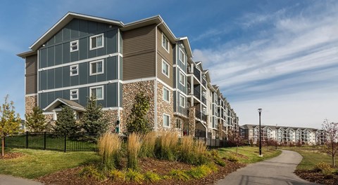 A modern apartment building with beautiful landscaping out front.