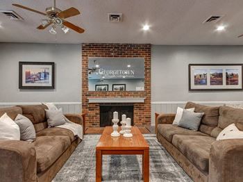 A living room with a fireplace and two couches.