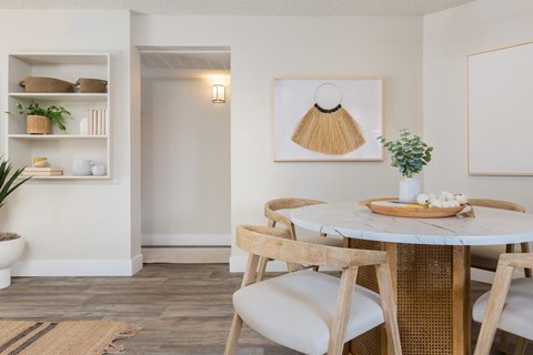 a small dining area with a round table and wooden chairs