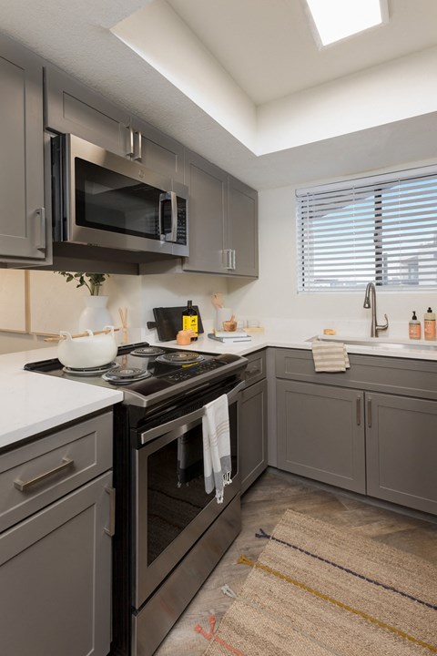 A kitchen with a black stove top oven and a microwave above it.