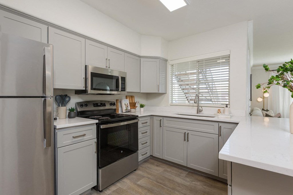 a kitchen with white cabinets and stainless steel appliances