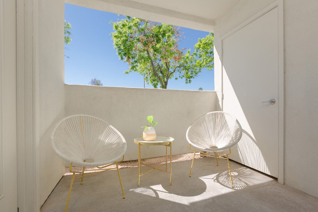 a room with two chairs and a table on a balcony