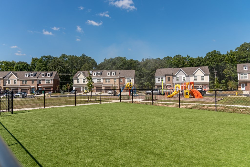 a playground in a park with houses in the background