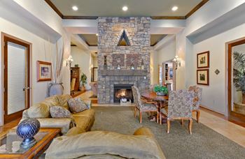 Living room with a stone fireplace and a dining room at Casoleil, San Diego