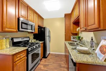 Kitchen with wood cabinets with granite counter tops at Sunbow Apartments, Chula Vista